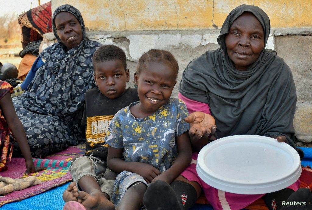 Women and their children who fled the war-torn Sudan following the outbreak of fighting between the Sudanese army and the paramilitary Rapid Support Forces (RSF), sit at the United Nations High Commissioner for Refugees (UNHCR) transit centre in Renk, near the border crossing point in Renk County of Upper Nile State, South Sudan May 1, 2023. REUTERS/Jok Solomun