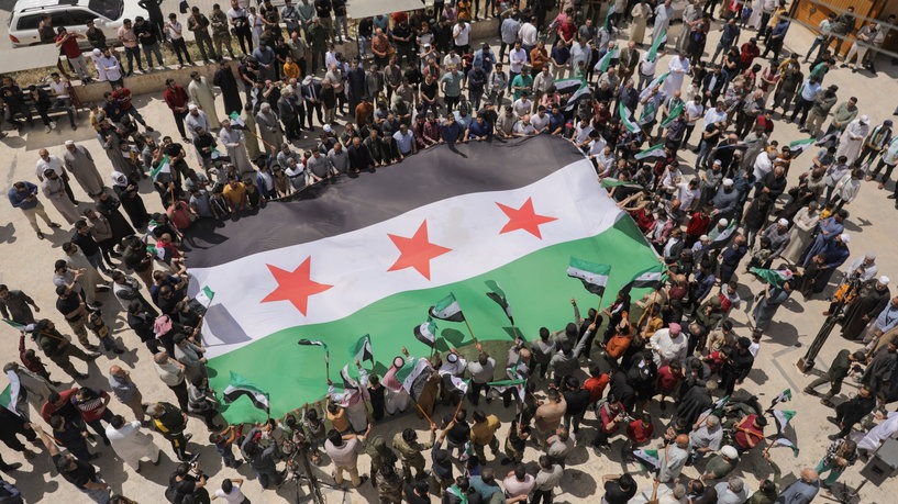 Demonstrators hold the Syrian opposition flag as they gather during a protest against Arab normalization with Syria's President Bashar al-Assad and the Arab League's reintegration of Syria, in the rebel-held city of Azaz, Syria May 19, 2023. REUTERS/Khalil Ashawi